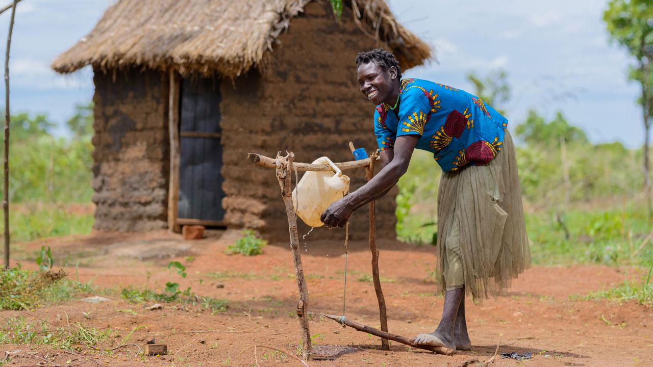 乌干达Kitgum地区，一名妇女在用完家里的厕所后洗手。在该地区，利乐全球最大体育平台主导的水和卫生项目增加了使用厕所和洗手站的机会